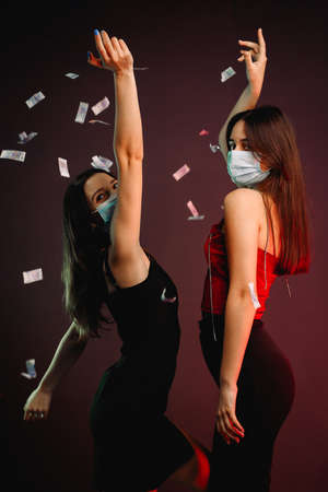 Side view photo of elegant girlfriends with long hair wearing medical masks on the party on pandemic time.の写真素材