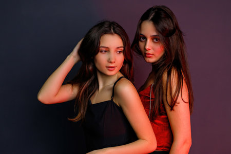 Photo of two gorgeous friends with amazing looking posing for camera in evening wearing ready to the party.の写真素材