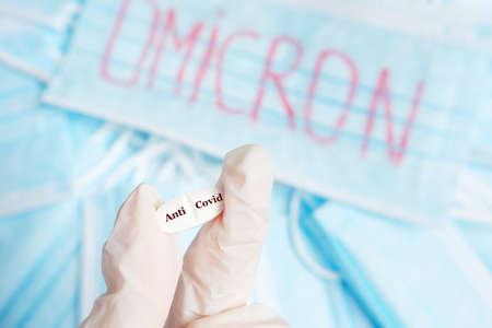 Hands of scientist or doctor holding Anti Covid- 19 pill against Omicron stem fighting concept.の写真素材