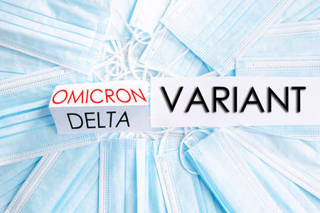 Face medical masks with inscriptions of omicron delta new covid variant, protection and health concept.の写真素材