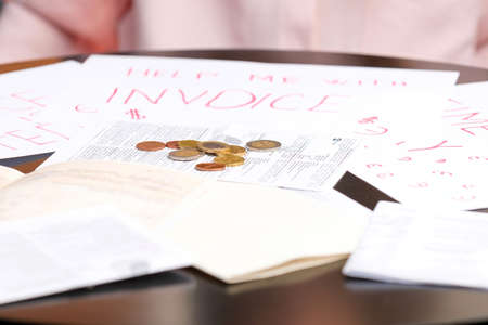 Photo of payments of invoices on the table with coins, situation in business crisis and problem concept.の写真素材