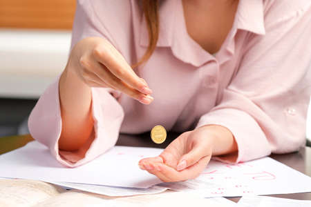 Photo of two woman hands counting coins to make invoice payments having documents on the table, paying bills problem concept.の写真素材