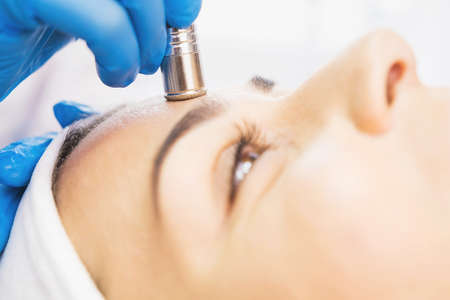 Close up photo of a woman undergoes procedure microdermabrasion against acne and blackheads in a beauty salon.の写真素材