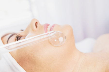 Cosmetologist specialist makes procedure microdermabrasion on the woman face against acne in the...