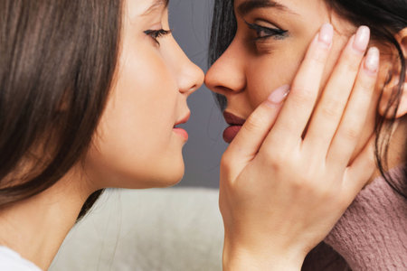 Close up side view photo of two girls in love looking at each other enjoying intimate tender sensual moment together, lesbian couple concept.の写真素材