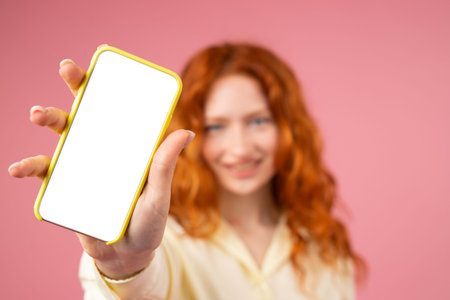 Blurry photo of a young lady with redhead hairstyle and blue beautiful eyes showing on camera mobile...