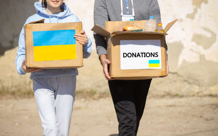 Young volunteers taking a box of food from his car for the Ukrainian refugeeの写真素材