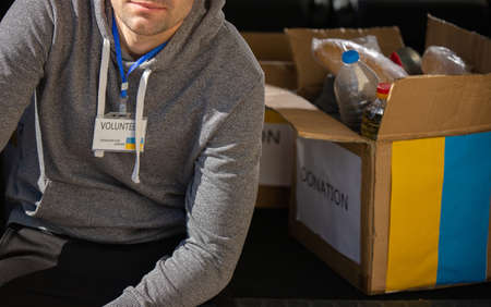 Cropped photo of a man volunteer taking a break from work with charity for ukranian refugees running away from the war.の写真素材