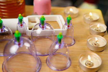 Picture of vacuum banks and candles on the table in spa salon, masseur using them to relax person body, health body concept.の写真素材