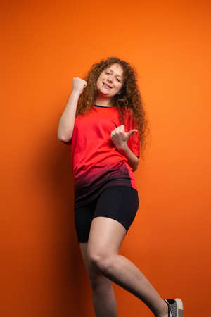 The young redhead woman in soccer football uniform having victiry mood as her team became winner, fan support concept.の写真素材