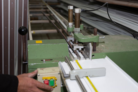 Male hand presses buttons on a construction machine for manufacturing of skirting boards in a factory, hard and concentrated work concept..の写真素材