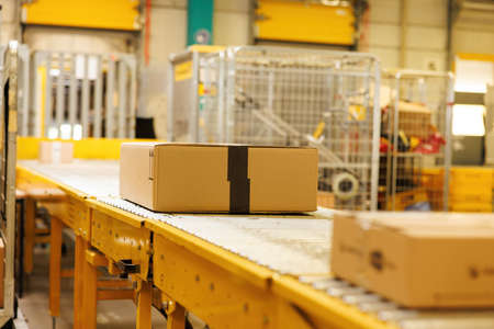 Box on conveyor roller. Delivery service, distribution warehouse and parcels transportation system.の写真素材