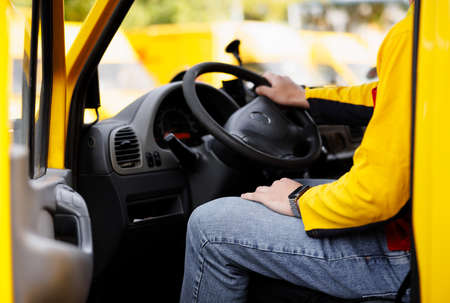 A uniformed employee. Delivery man is reading for driving vanの写真素材