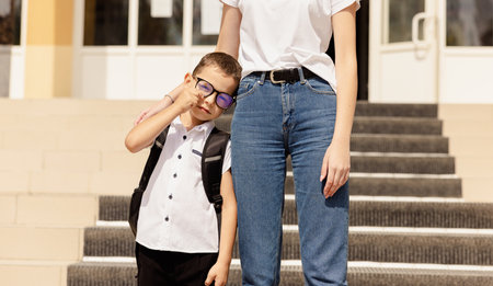Mother with her son in front of the school. First day of school concept.の写真素材
