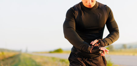 Athletic runner start training on fitness tracker or smart watch and looking forward on horizon. Trail running and active lifestyle concept.の写真素材