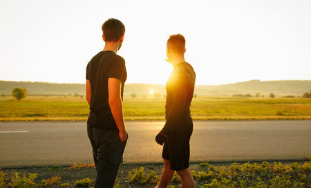 2 friends admire the beautiful view before starting to run on the field.の写真素材