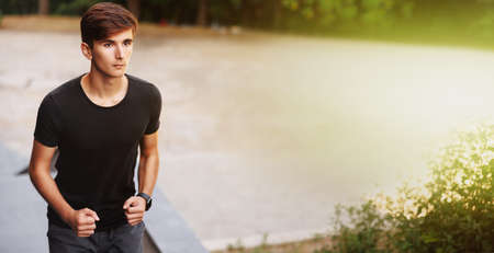 Athletic young man running on some stairs in the city. Serious face.の写真素材