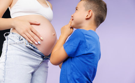 Portrait of a child and a pregnant woman. The listens to what is going on in my mothers belly. Photo closeupの写真素材