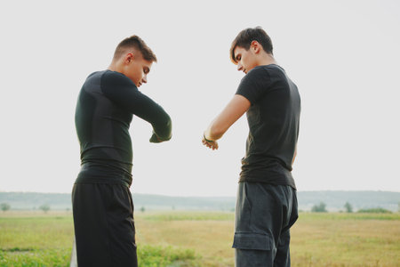 2 sportsman after training look at their smart watches that show them how many calories they burned todayの写真素材