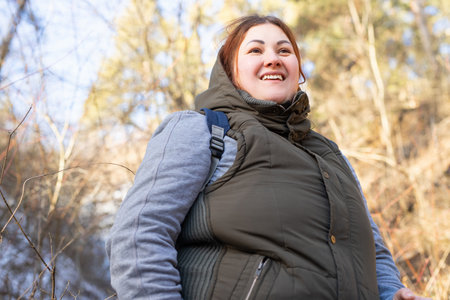 Close up photo of a woman with redhair hiker dressed warmly enjoying being in the forest feeling relaxed and calm.の写真素材