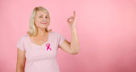 October Breast Cancer Awareness month, Woman in pink T- shirt with Pink Ribbon for supporting people living and illness. Healthcare, International women day and World cancer day conceptの写真素材