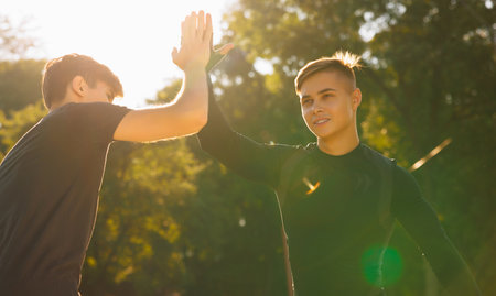 Two athletes clap their hands after finishing the exercises, they are happy that they are done and can go home.の写真素材