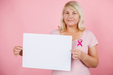 Woman doctor take bliiboard and show something with breast cancer prevent concept.の写真素材