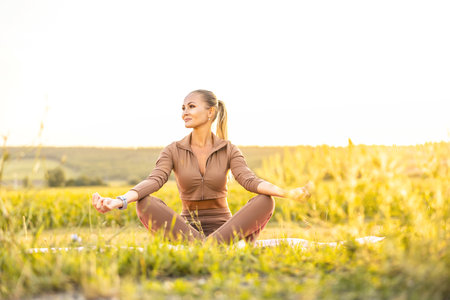Young woman doing yoga in morning park Calmness and relax, female happiness. Healthy concept.の写真素材