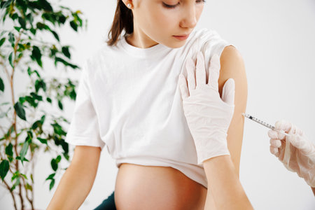 The doctor injects a pregnant girl. She came to the clinic to the gynecologist for an examination.の写真素材