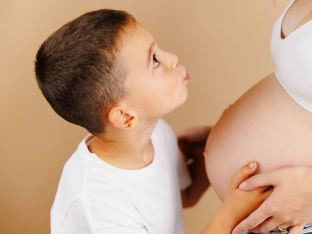 Boy kissing the belly of his mother.の写真素材
