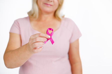 Woman in pink shirt with breast cancer awareness ribbon.の写真素材