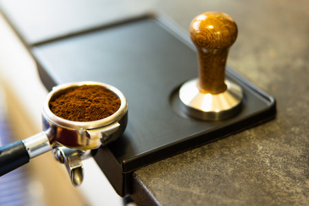Still Life of Wooden Spoon with Roasted Coffee Beans, Cinnamon Sticks and Star Anise on Cloth with Traditional Hand Grinder with Fresh Ground Coffee with Copy Space in Upper Cornerの写真素材