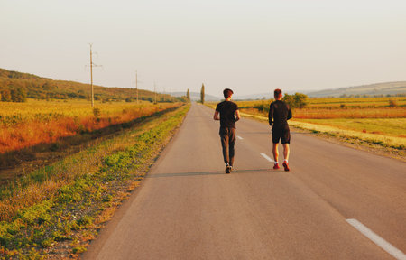 The two sportsmen running on the street. They look very nice in black sports suits.の写真素材