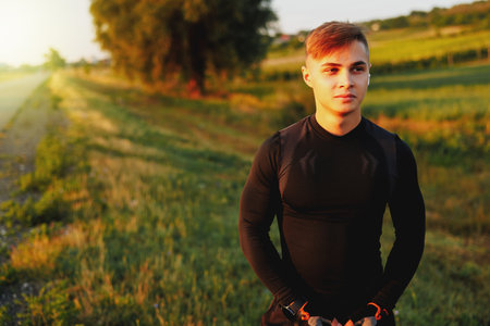Athletic man before morning run outdoors. Dressed in a beautiful black sports suitの写真素材