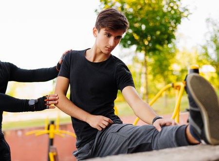 Young athlete man streching in the park outdoor. male runner warm up ready for jogging on the road outsideの写真素材
