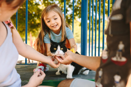 Family kicks a cat at a childrens playground.の写真素材