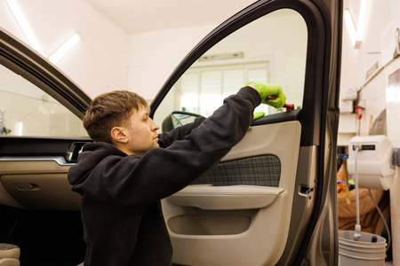 Young man repair vehicle interior doors of a car with special toolsの写真素材