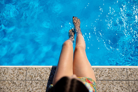 Enjoying a delightful and relaxing experience by the poolside surrounded by beautiful blue waterの写真素材