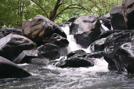 a beautiful miniature waterfall falling through the rocksの写真素材