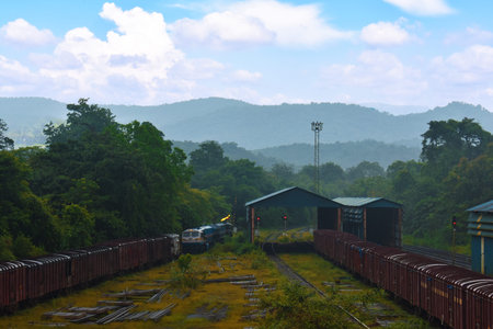 indian rail carriage waiting in its shed with a beautiful mountain in the background in Goa, India