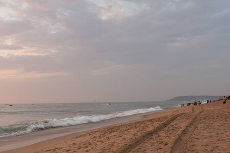 a sand trail of a car in a beach with wavesの写真素材