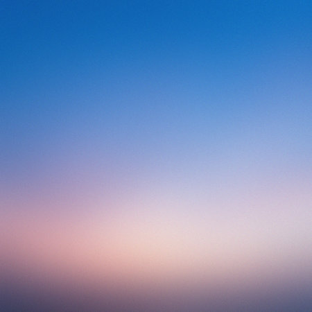 A vibrant blue sky smoothly fades into a soft pink horizon in this abstract gradient background.の写真素材