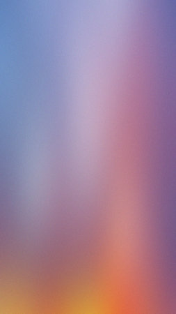 A blurred gradient background blends blue, purple, and orange tones with a soft, diffused effect.の写真素材