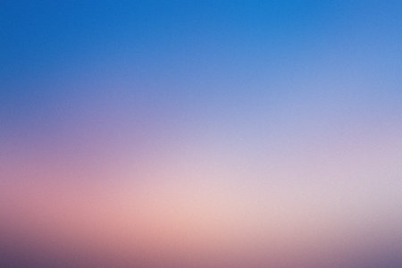 A gentle gradient of blue and peach hues with a soft focus effect creates an abstract background.の写真素材
