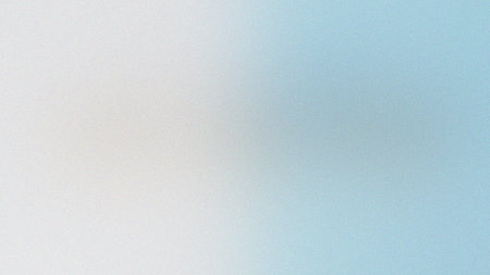 A smooth gradient transitioning from white to light blue with a subtle grain texture.の写真素材