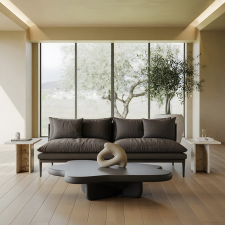 Modern living room with a dark sofa, sculptural coffee table, and a large window with trees.