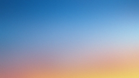 A blurred gradient of blue, orange, and yellow evokes a sky at sunrise or sunset, with soft light.の写真素材