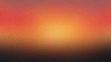 A warm gradient background with intense orange and yellow hues fading into dark tones.の写真素材