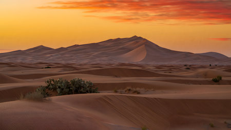 Rolling desert sand dunes under a vibrant orange and yellow sunset sky. Clear details and vibrant...の写真素材