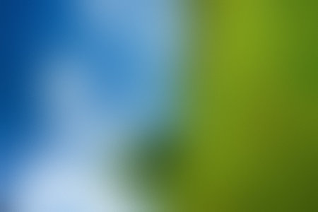 A soft, blurred background blends blue sky tones with vibrant green hues. Clear details and vibra...の写真素材